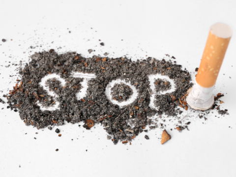 Cigarette next to ashes with the word "Stop" in the middle. 
