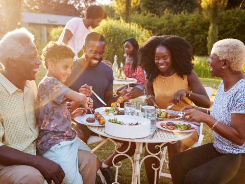 Black family eating together outside. 