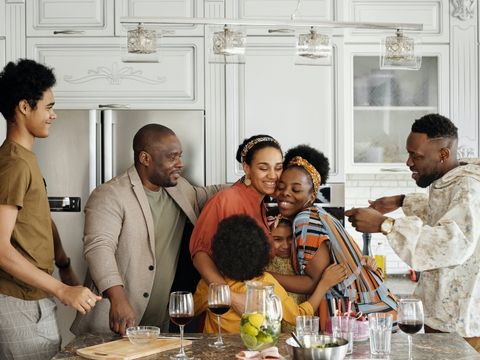Family smiling around kitchen table. 