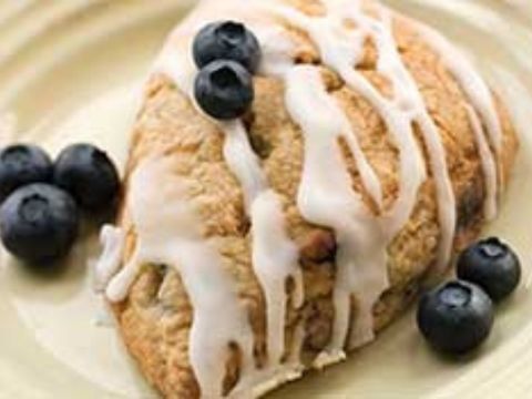 Blueberry Streusel Scone on plate with extra blueberries. 