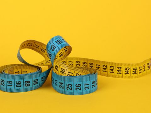 Tape measure on yellow background. 