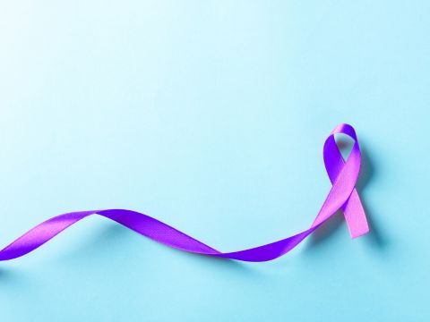 Purple testicular cancer awareness ribbon on a light blue background. 