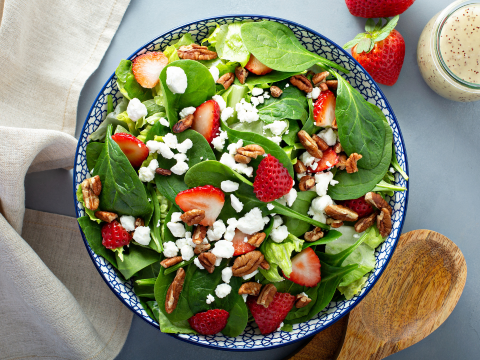 Strawberry spinach salad in a bowl on the table. 