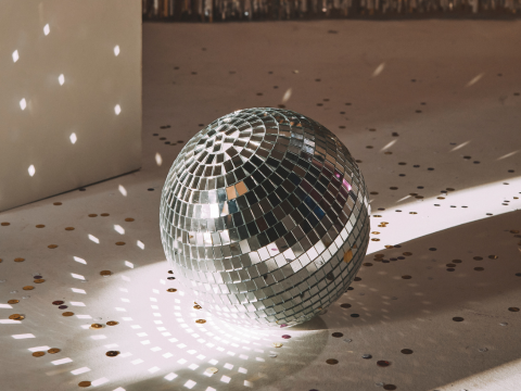 disco ball shining on the ground with confetti. 