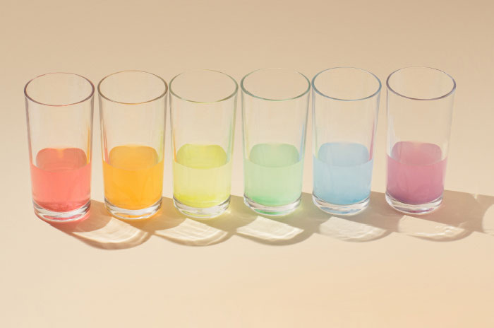 Glasses linked up with different colored liquids. 